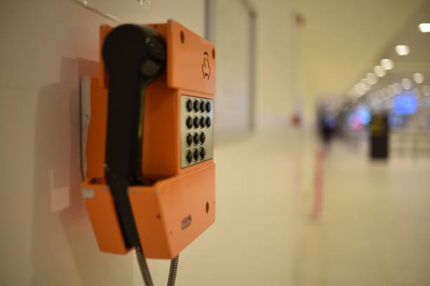 istock Traditional orange and black wall-mounted phone is affixed to a vertical surface 1768469080