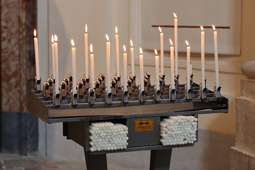 Votive stand in a church filled with tall candles