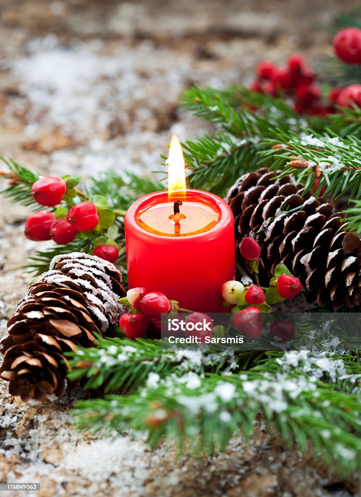 Christmas decoration of a red candle and pine cones "Christmas decoration with winter berries,candle,pine cone and fir tree" Advent Stock Photo