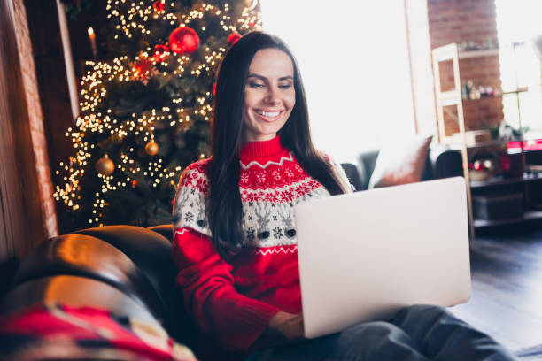 istock Portrait of cheerful lovely girl dressed red pullover sitting on couch writing sms message macbook netbook holiday atmosphere indoors 1768491021