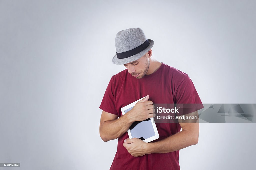 Красивый человек с шляпу, huging планшетный ПК - Стоковые фото Горизонтальный роялти-фри