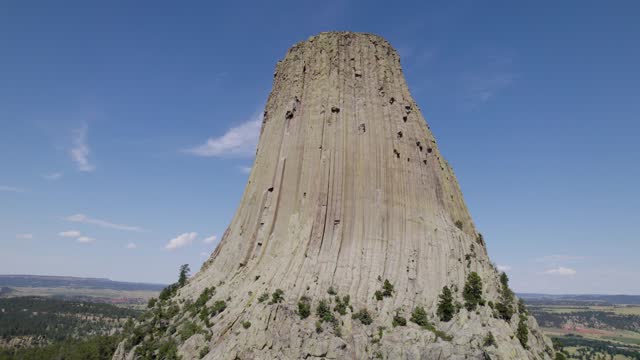 A drone shot of Devils Tower, a massive, monolithic, volcanic stout tower, or butte, located in the Black Hills region of Wyoming.