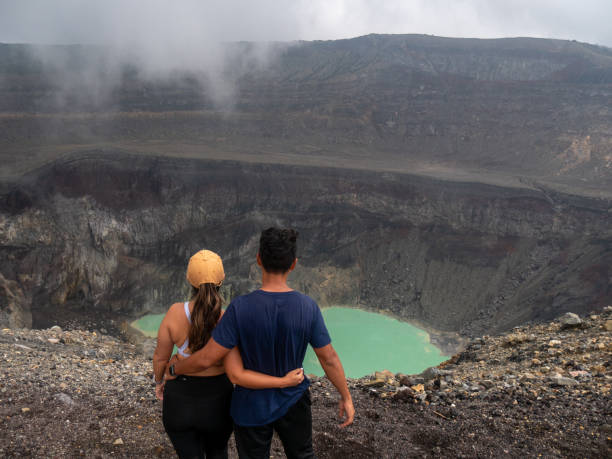 couple contemplating a volcano crater, sports clothing - el salvador lake scenics nature imagens e fotografias de stock