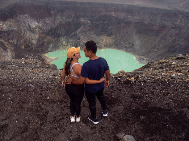 couple contemplating a volcano crater, sports clothing - el salvador lake scenics nature imagens e fotografias de stock