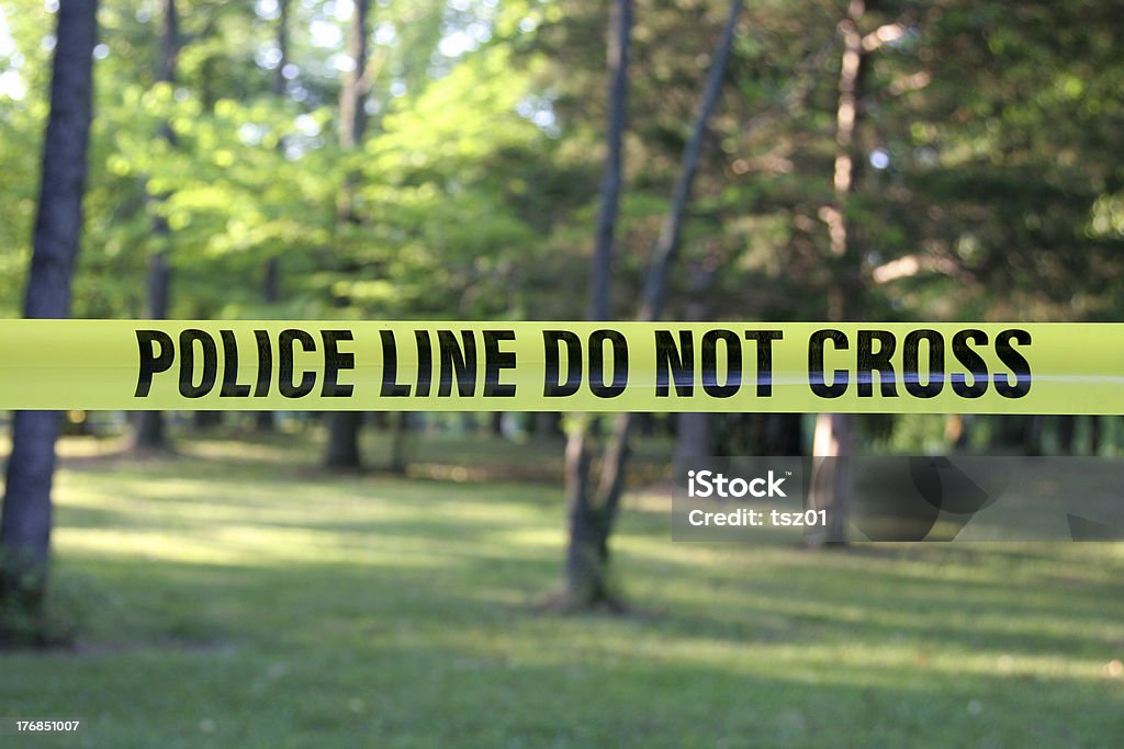 Police Do Not Cross Tape Police Do Not Cross aa yellow plastic tape in a forest. Loneliness Stock Photo