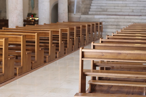Rows of wooden pews in an empty church