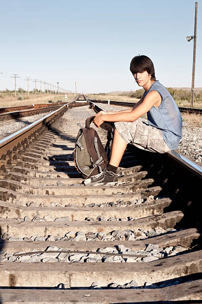 istock Teen boy with problems sitting on rail road 176851277