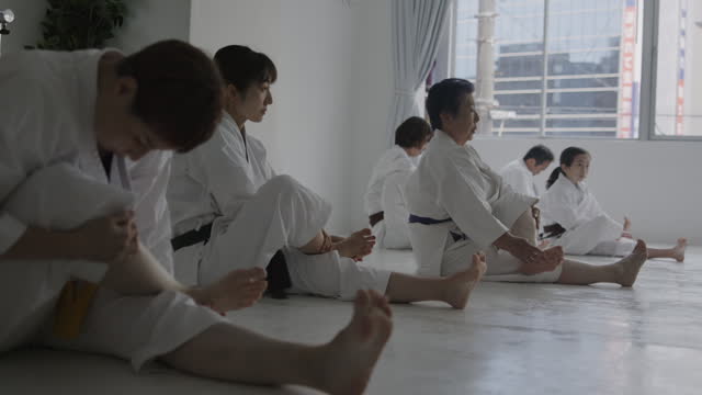 Japanese people stretching and warming up at karate class