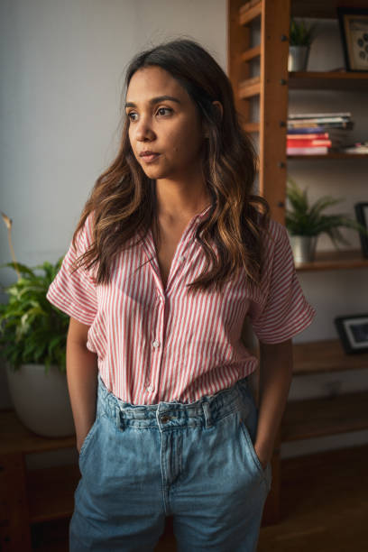 istock Woman standing and looking out the window 1768527483