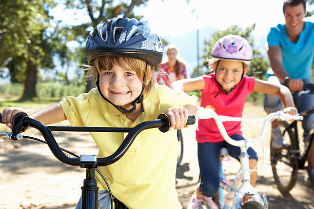joven familia en bicicleta de país viaje - casco de ciclista fotografías e imágenes de stock
