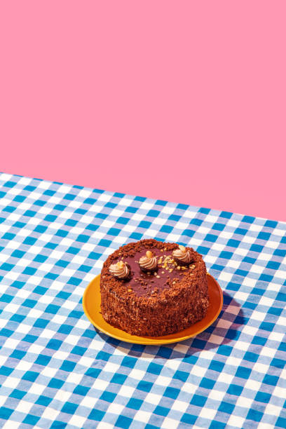istock Chocolate delicious cake on plate on blue checkered tablecloth over pink background. Sweet food, birthday 1768528077
