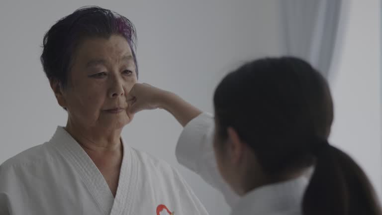 Young Japanese girl and mature woman practise karate together