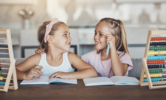 Students, girl children and education, notebook and abacus with studying and learning while at home. Happy kids, smile with friends or sister, help and support with books, math and numbers at table