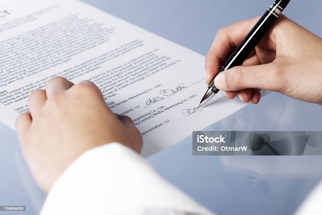 Macro of businesswoman signing contract. "Close up of woman signing a legal document or contract, blank background.Similar images in my portfolio:" Adult Stock Photo