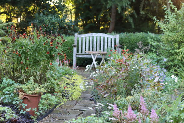 istock Bench and table at the end of a path, in a garden in summer 1768560902