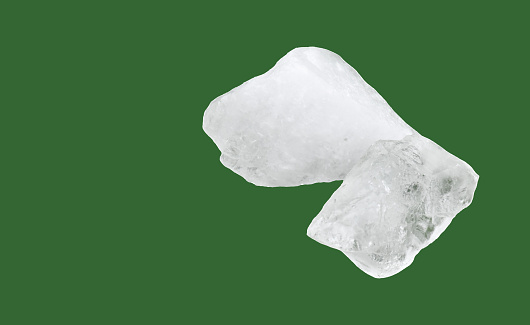 White alum cubes isolated on green background, alternative medical treatment and body care concept.