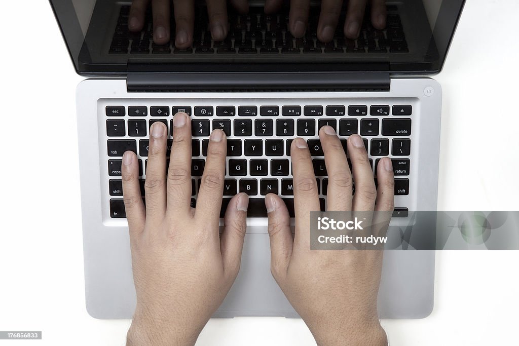 Typing on Notebook Man hands typing on Notebook keyboard Activity Stock Photo