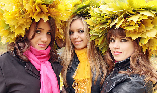 Three young beautiful women in the wreaths from leaves