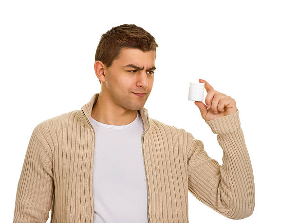 istock man holding a bottle of medicine 176857424