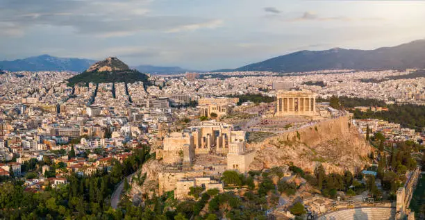 Aerial close up view of the Acropolis of Athens, Greece, with Parliament Building and Lycabettus hill during sunset time