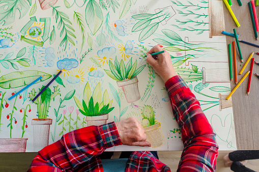 One senior woman is making vibrant drawing for Earth day celebration.