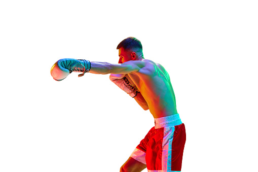 Side view. Sportsman, boxer, mixed martial art fighter workout against white background in mixed neon filter, light. Concept of sport, action, motion, healthy lifestyle. Copy space for ad.