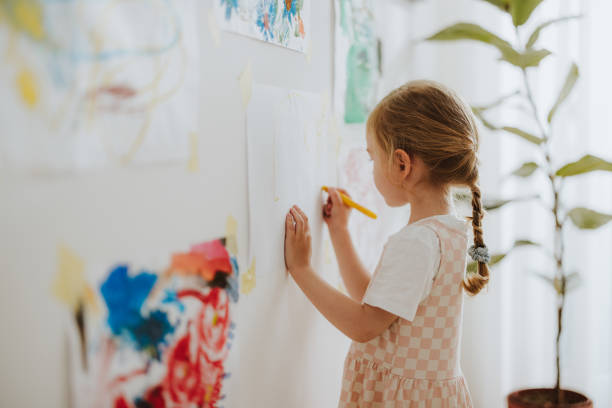 istock Unrecognizable Girl Drawing On Papers At The Nursery Wall 1768580346