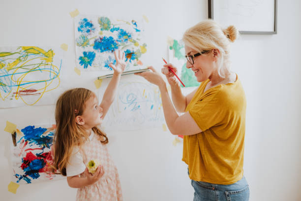 istock Happy Mother Having Fun While Measuring Daughter's Height At Home 1768580749