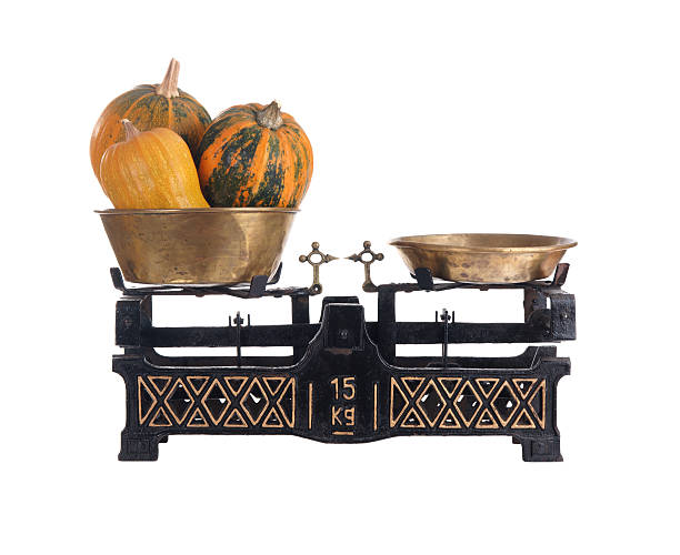 Old-fashioned balance scale with pumpkins isolated on white background