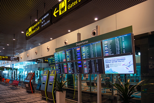 Changi Airport, Singapore - January 24, 2020: Real photo of departures board in Singapore airport  viewed from the main corridor