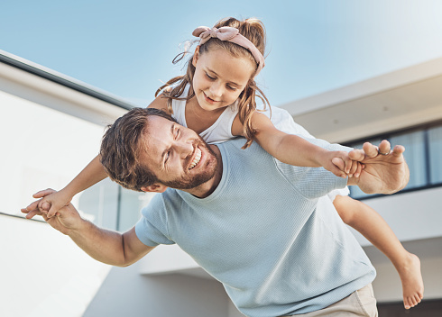 Father playing, piggyback or child in new home as a happy family on real estate with love, smile or care. Airplane, flying or fun kid with proud dad on property in relocation together in dream house