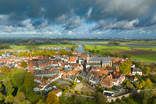 Hattem aerial view during a beautiful fall day. The town Hattem is bordering the forests of ‘De Veluwe’ on one side and lies along the IJssel river the other side, which can be seen in the background.