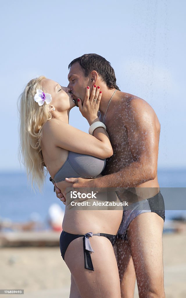 Attractive couple at the sea Middle aged man and young pregnant woman on the beach Women Stock Photo