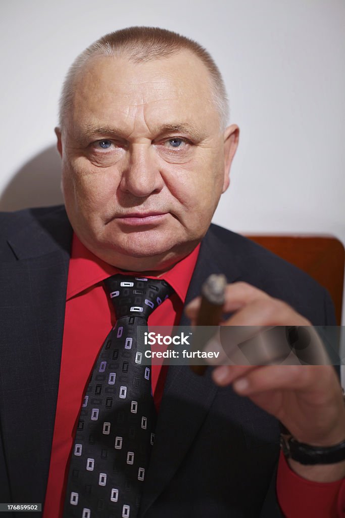 Confident boss with cigar Portrait of serious businessman in black suit and red shirt with cigar Criminal Stock Photo