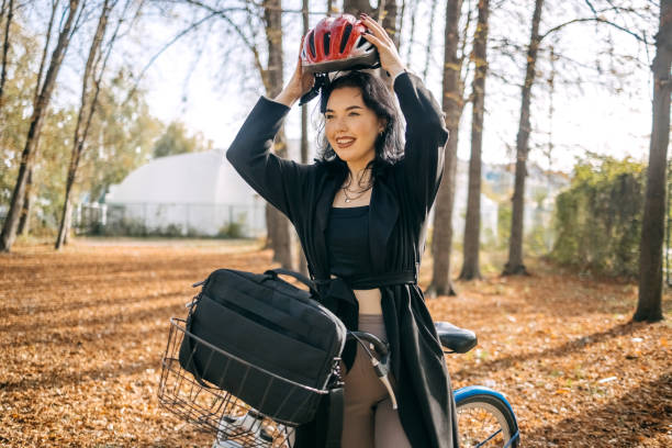 Young business woman going to work through city park