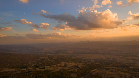 Warm sunset paint landscape in orange. 
Wide shot of valley at sunset, aerial drone point of view.
