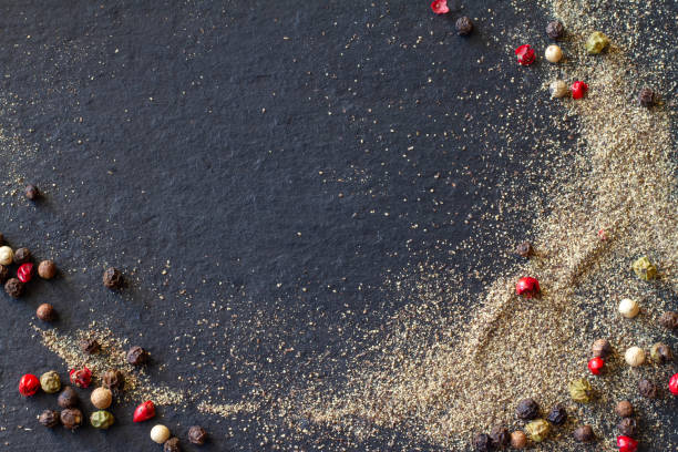 istock Ground pepper and colored peppercorns on black background, copy space 1768603756