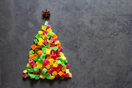 Colorful Christmas tree made of candied fruits on dark background, christmas concept food