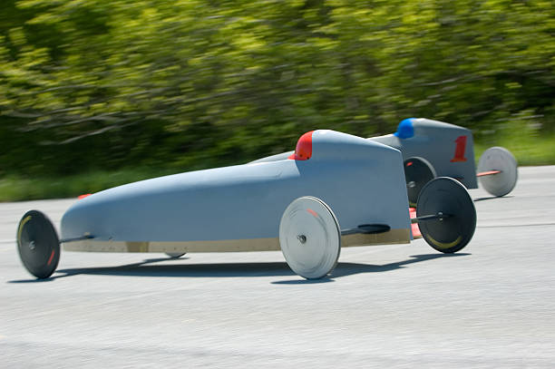 Soap Box Derby Two soap box race cars speed down the track. Panning blur captures sense of speed and slow shutter allows spinning tires show rotation as well.Related Lightboxes - soapbox cart stock pictures, royalty-free photos & images