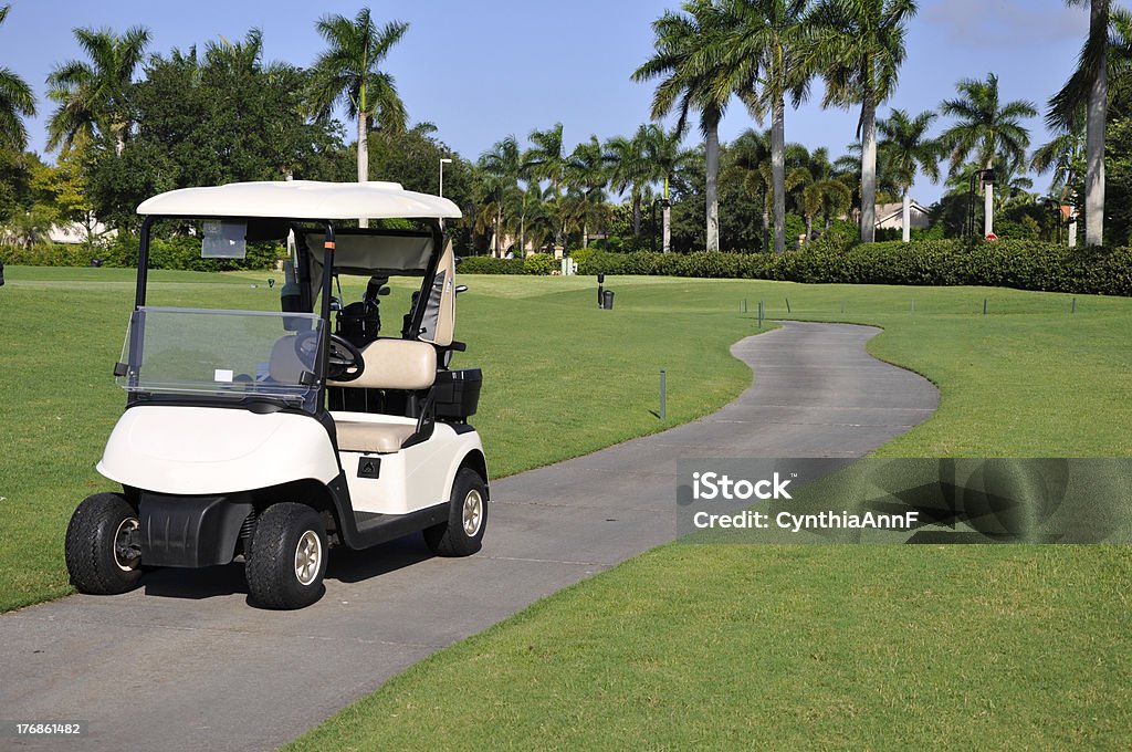 empty golf cart "Empty golf cart sitting on a macadam path by a golf course in Naples, Florida." Golf Course Stock Photo