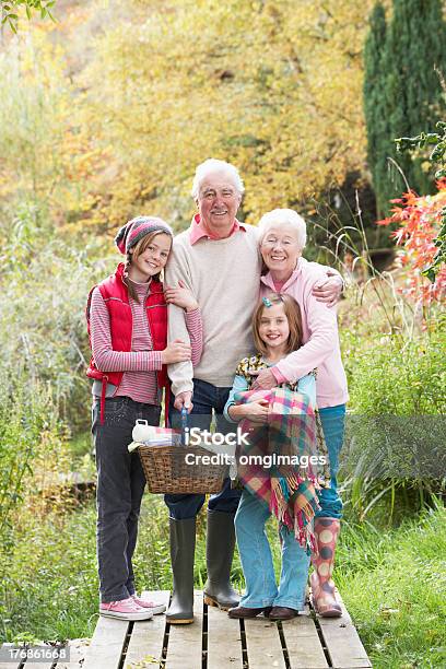 Grandparents With Grandchildren Carrying Picnic Basket By Autumn Stock Photo - Download Image Now
