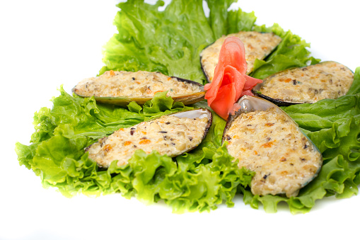 sliced mussels on lettuce leaves isolated on a white background