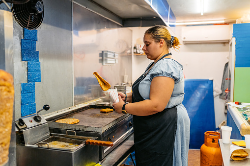 Female food service worker preparing gyros in a diner.