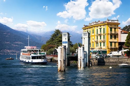 Holidays in Italy - Scenic view of the marina with a ferry in Varenna on Lake Como