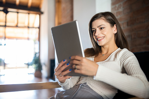 Woman is online banking at home from a mobile device easy and convenient.
