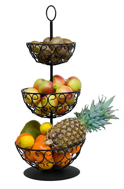 black wrought iron etagere filled with lots of various fruits. Studio shot in white back with clipping path