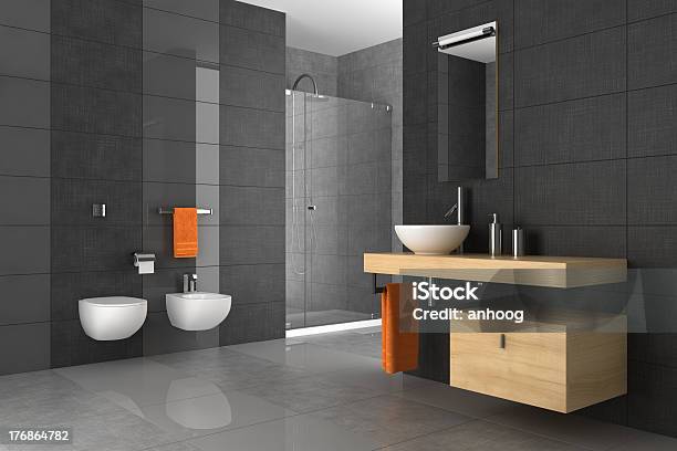 A Tiled Bathroom With A Wood Counter And Orange Towels Stock Photo - Download Image Now