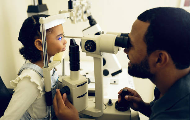 istock Eye doctor, machine or child consulting to help eyesight at optometrist for a optical assessment. Optician, slit lamp or kid in test for vision, iris or retina health with laser technology or man 1768648819