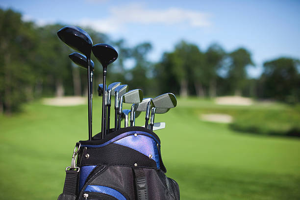 Golf bag and clubs against defocused green background stock photo