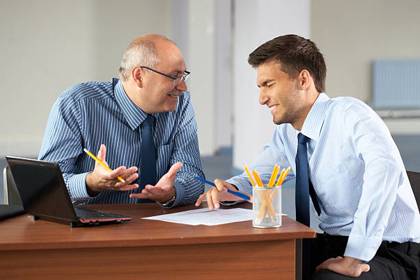 istock two businessman with laptop, office as background 176865327